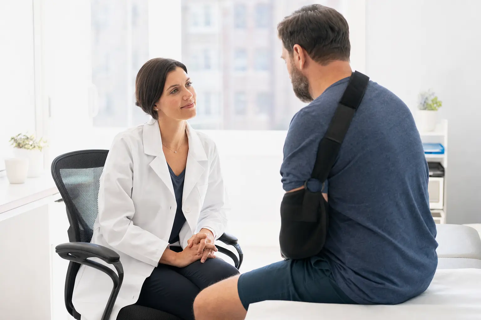 A Revita Motion physician listening to an injured patient during a consultation